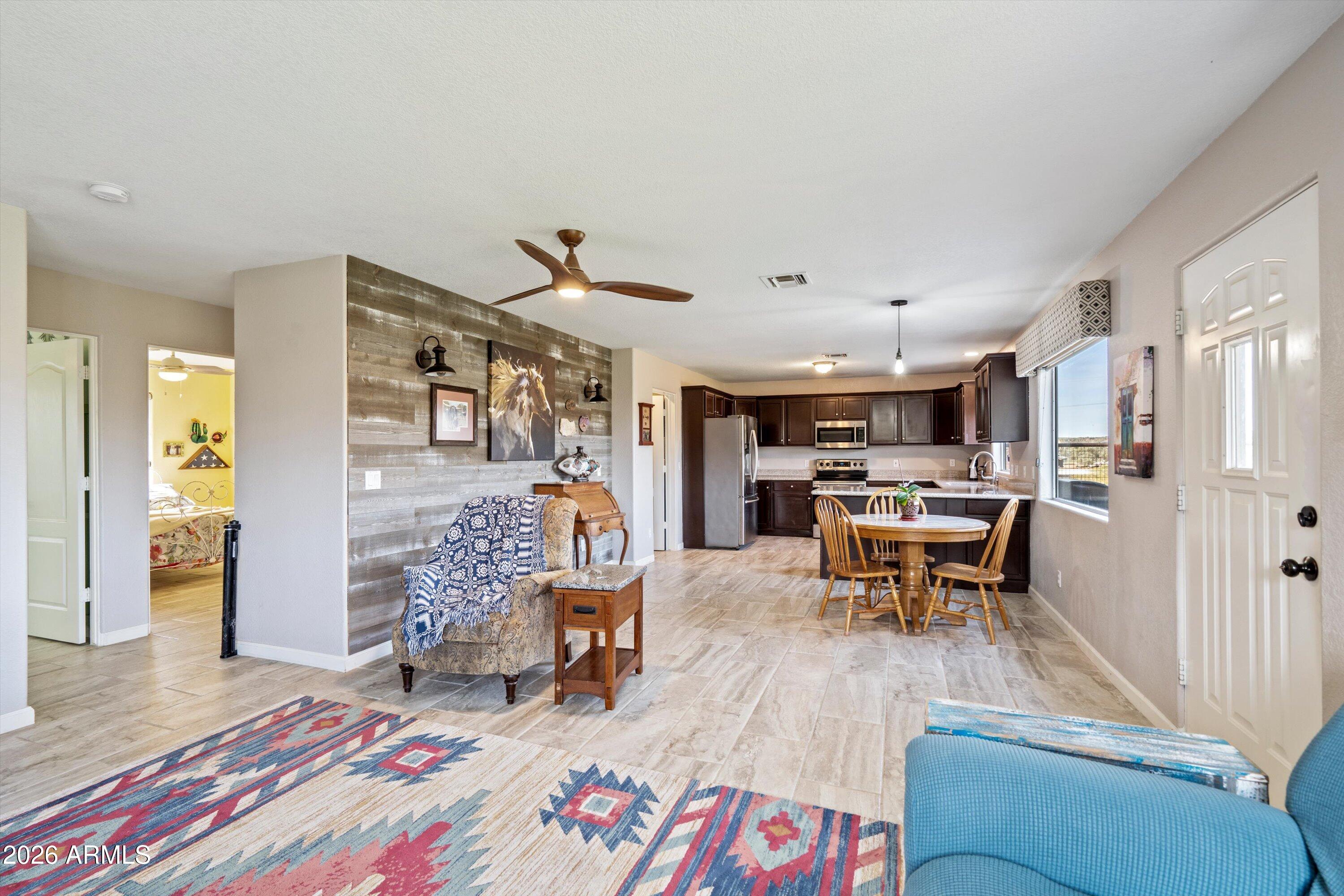 2316 West White Spar Road New River, AZ 85087 - Photo 7 of 40 a living room with furniture and a dining table with kitchen view