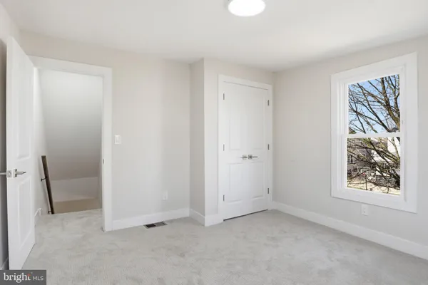 an empty room with windows and closet