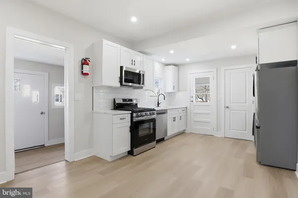 a kitchen with stainless steel appliances a refrigerator stove and microwave