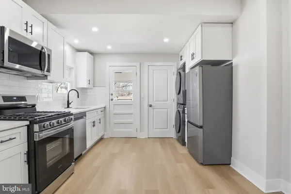 a kitchen with stainless steel appliances granite countertop a refrigerator stove and sink