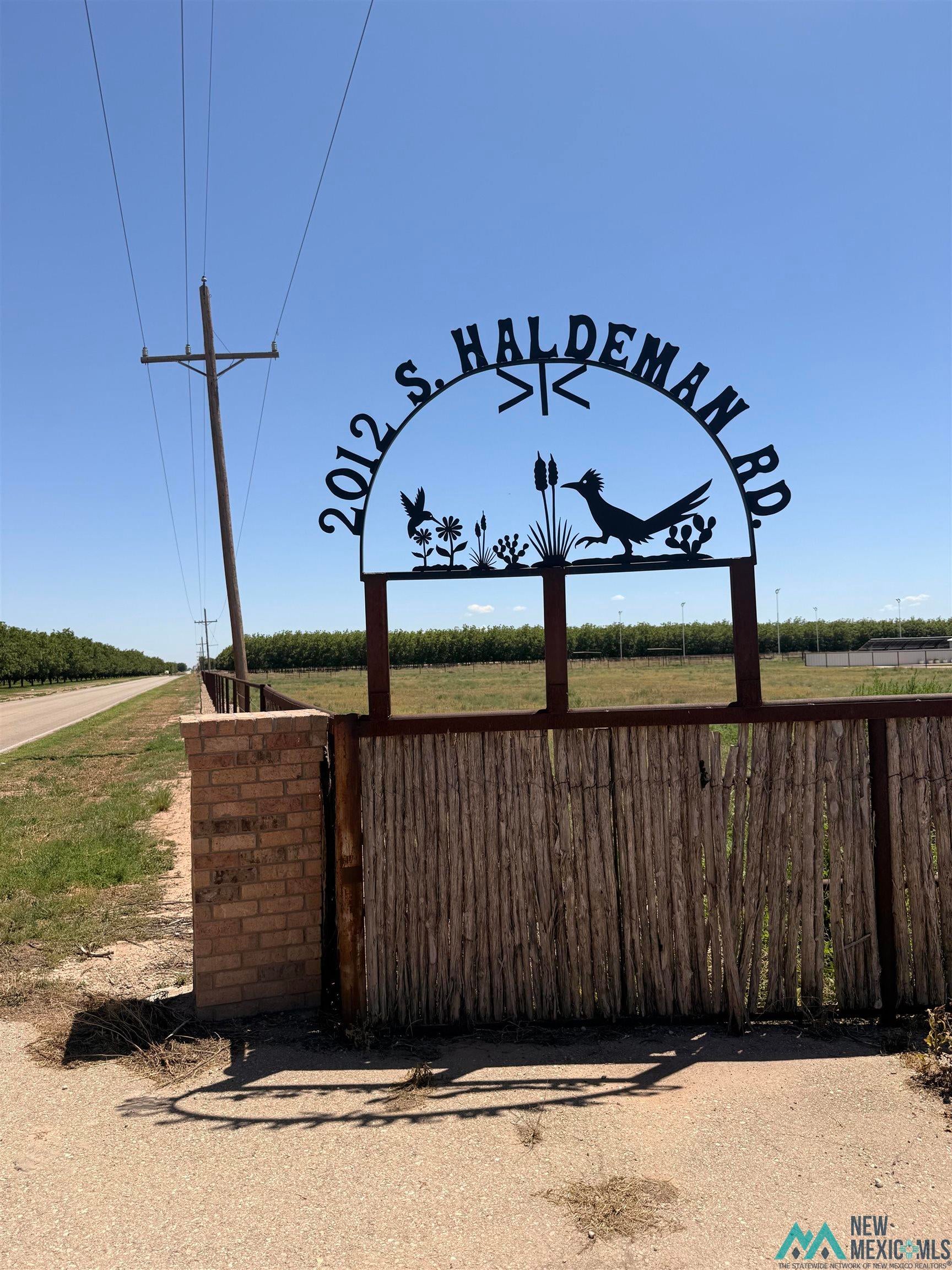 2012 South Haldeman Road Artesia, NM 88210 - Photo 87 of 96 Decorative metal signage with property address, flanked by a brick column and a rustic wood gate