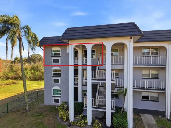 a view of a large building with many windows next to a yard