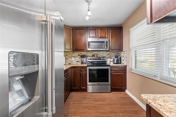 a kitchen with stainless steel appliances granite countertop a stove top oven and sink