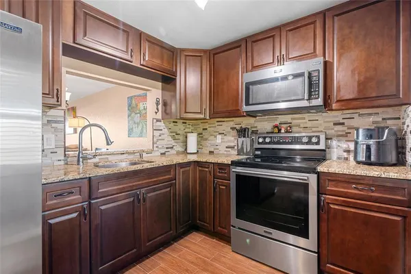 a kitchen with stainless steel appliances granite countertop a stove microwave and sink