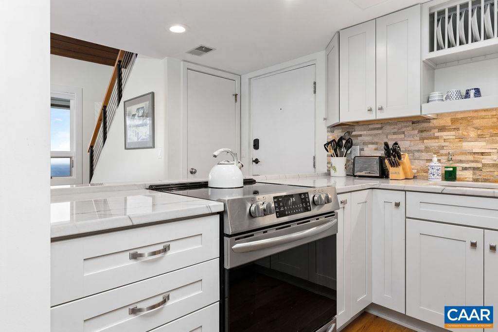 1478 Ledges Condos Roseland, VA 22967 - Photo 14 of 50 a kitchen with granite countertop white cabinets and white appliances