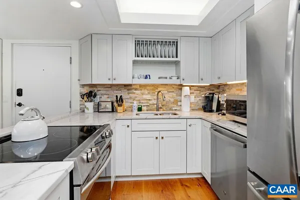a kitchen with stainless steel appliances granite countertop a sink stove and refrigerator
