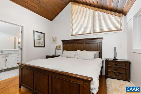 a bathroom with a granite countertop sink a mirror and shower