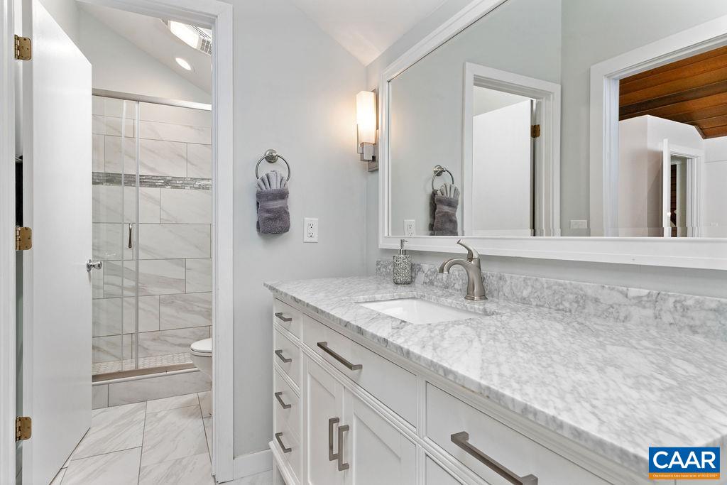 1478 Ledges Condos Roseland, VA 22967 - Photo 36 of 50 a bathroom with a granite countertop sink a mirror and shower