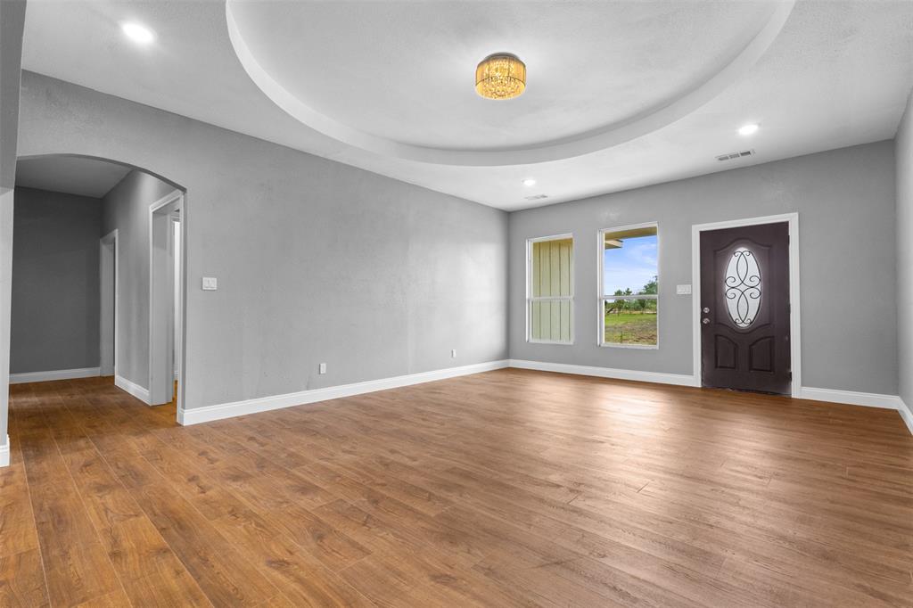 7074 Northeast County Road Rice, TX 75155 - Photo 4 of 22 an empty room with window and wooden floor