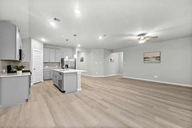 a kitchen with a sink cabinets and wooden floor