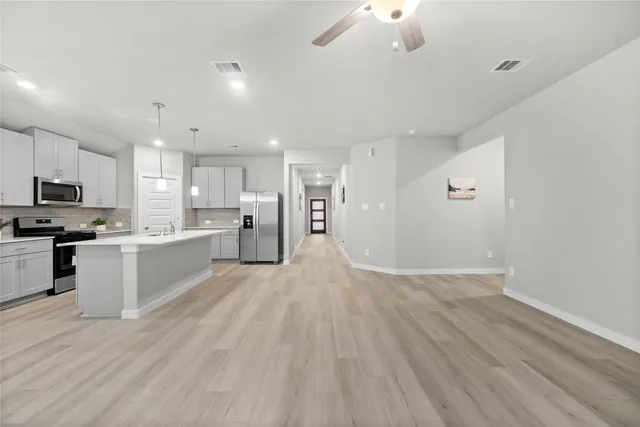 a view of kitchen with granite countertop cabinets and refrigerator