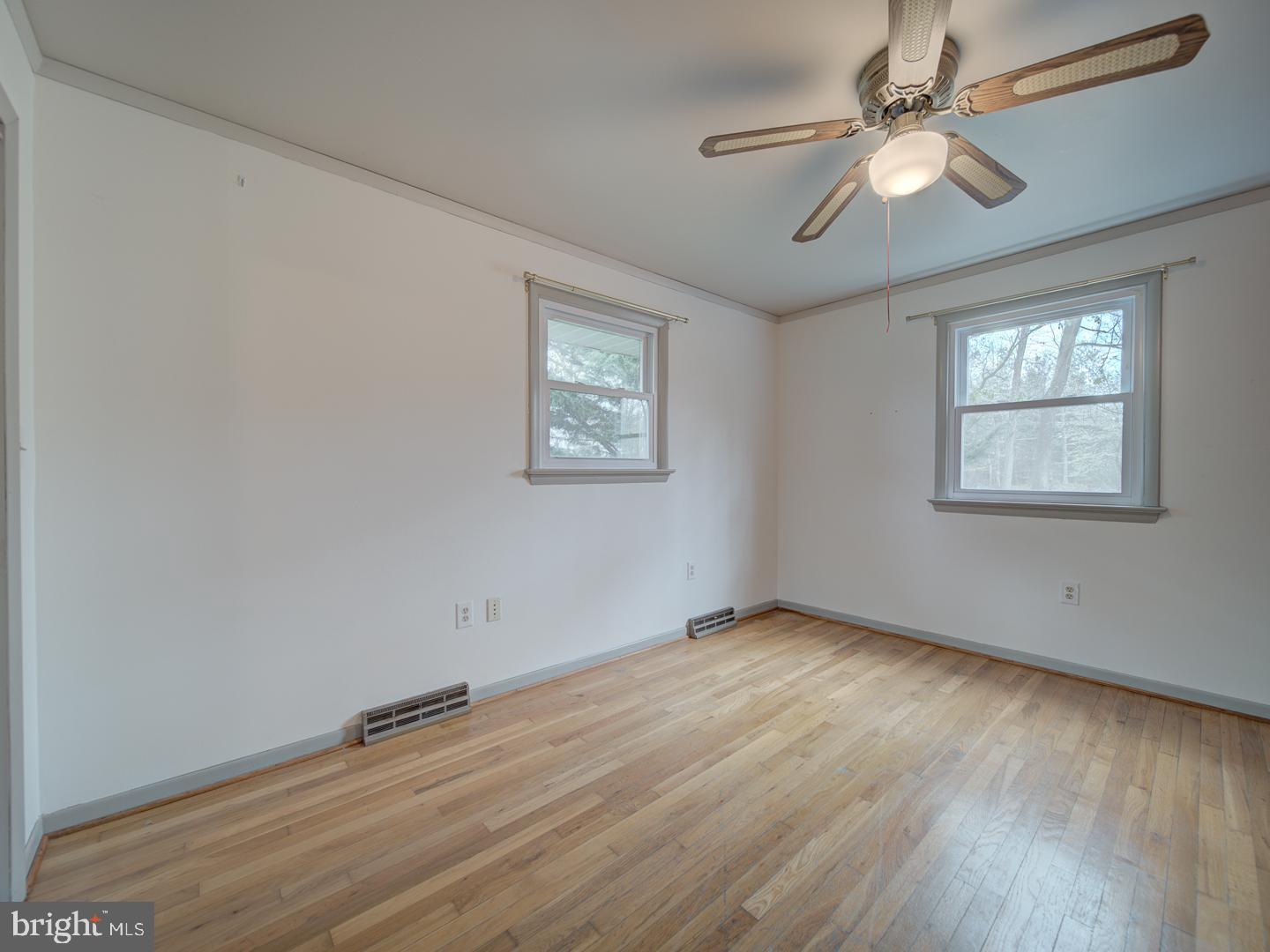 17520 Tranquility Road Purcellville, VA 20132 - Photo 28 of 70 an empty room with wooden floor chandelier fan and windows