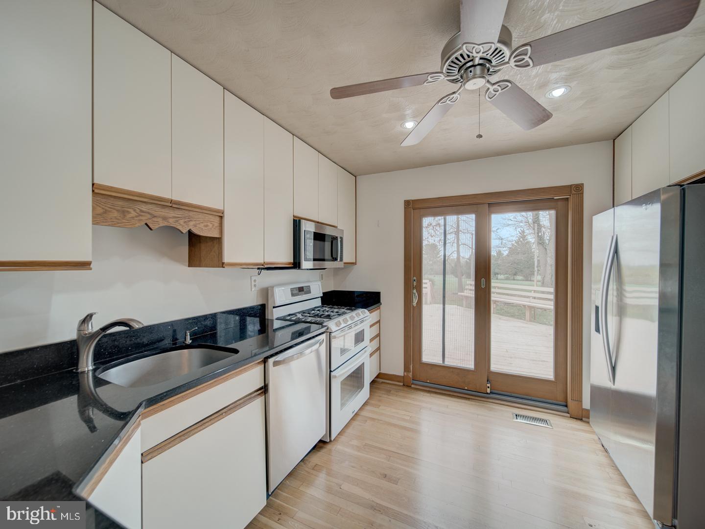 17520 Tranquility Road Purcellville, VA 20132 - Photo 40 of 70 a kitchen with stainless steel appliances granite countertop a stove a sink and a refrigerator with white cabinets