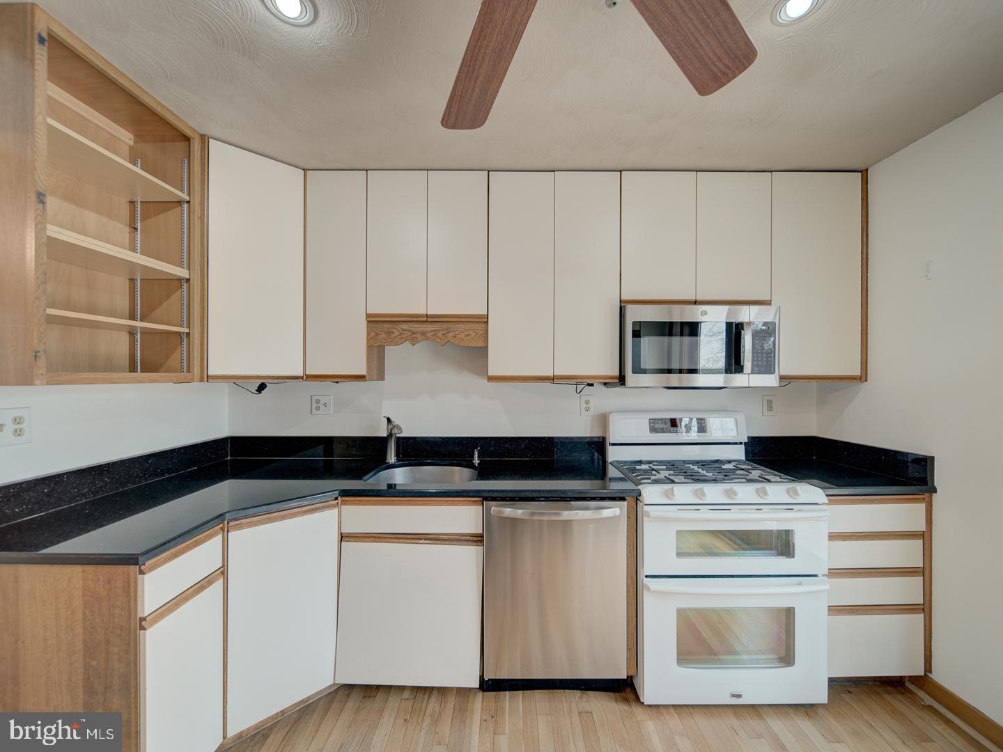 17520 Tranquility Road Purcellville, VA 20132 - Photo 42 of 70 a kitchen with granite countertop white cabinets and white appliances