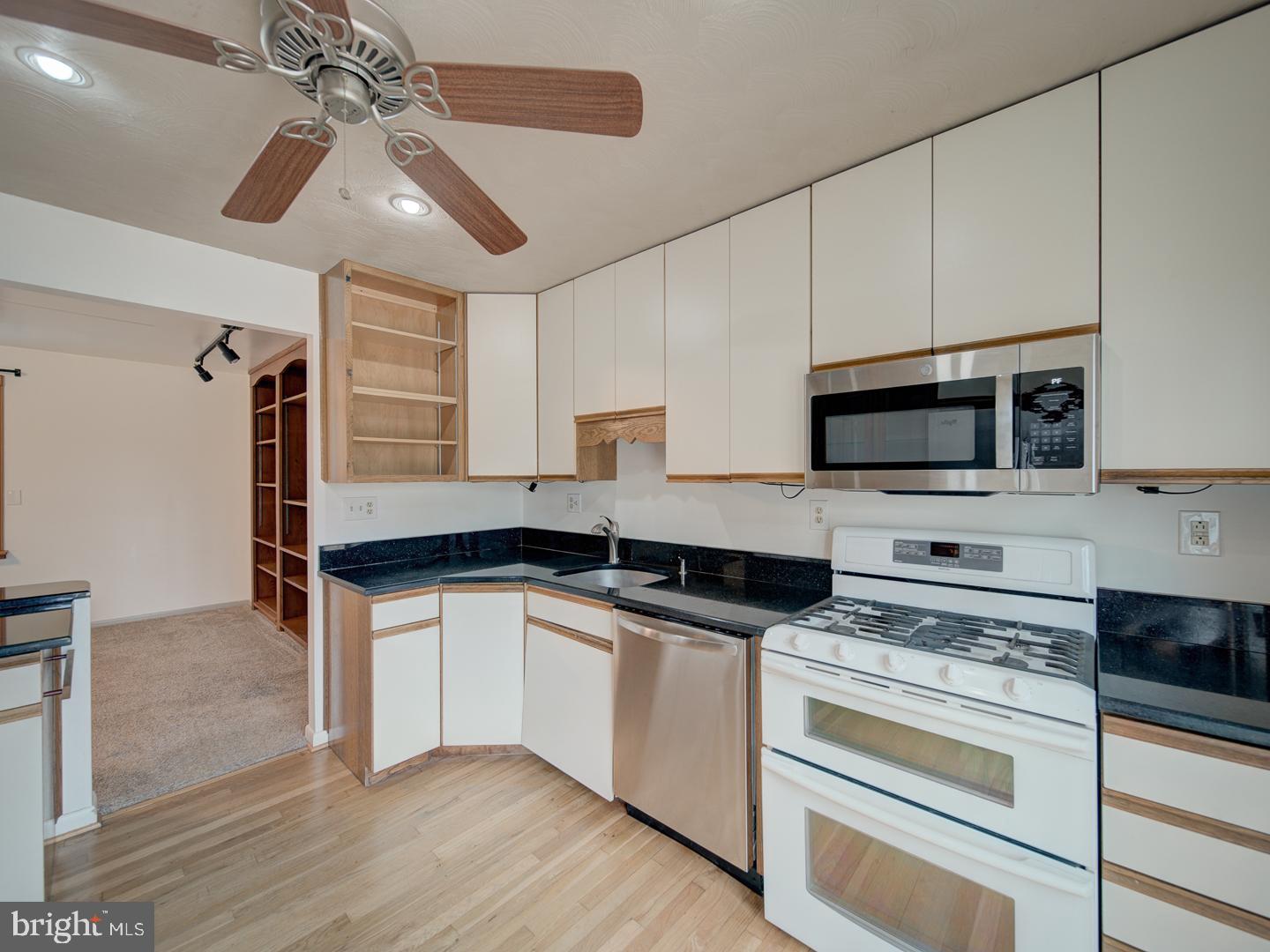 17520 Tranquility Road Purcellville, VA 20132 - Photo 46 of 70 a kitchen with granite countertop a sink stainless steel appliances and white cabinets