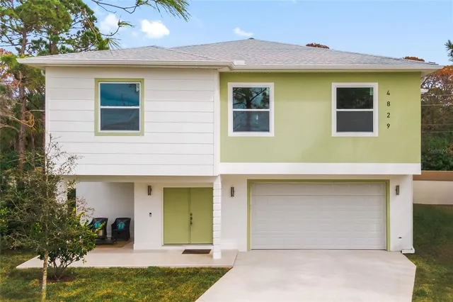 a front view of a house with a yard garage and outdoor seating