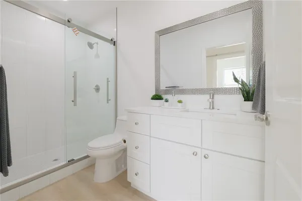 a bathroom with a sink a toilet and shower