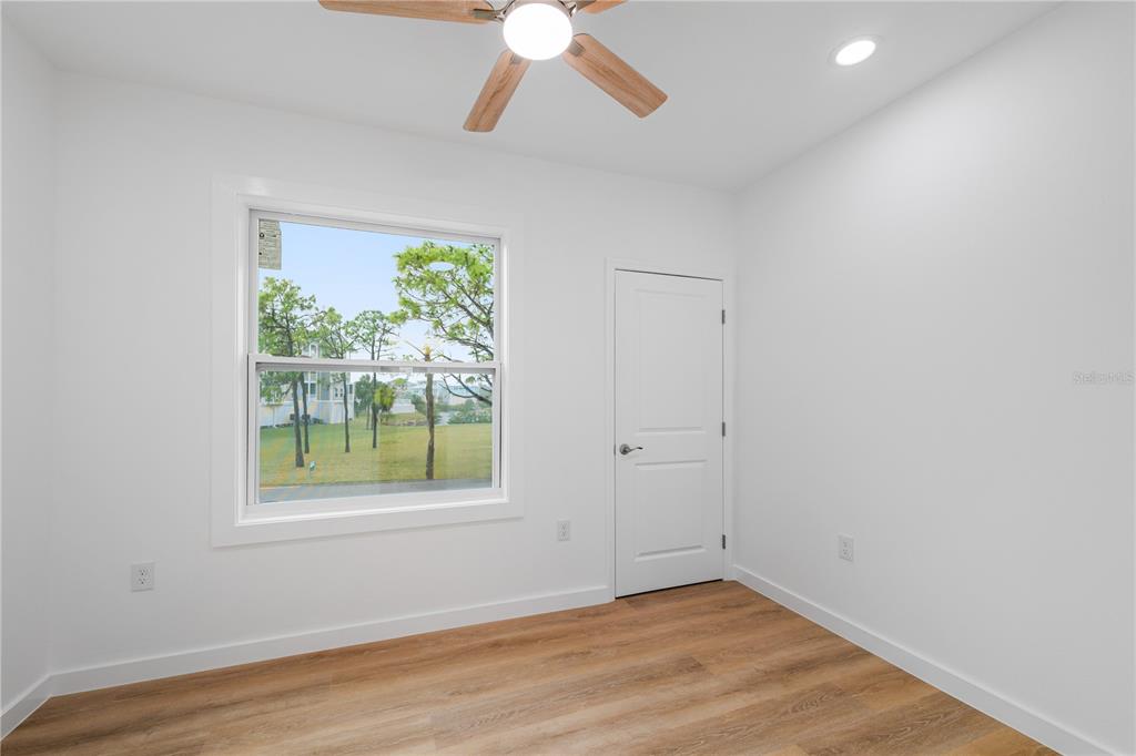 4829 Jenny Way New Port Richey, FL 34652 - Photo 15 of 30 an empty room with wooden floor chandelier and windows