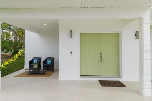 a view of a house with a yard and potted plants