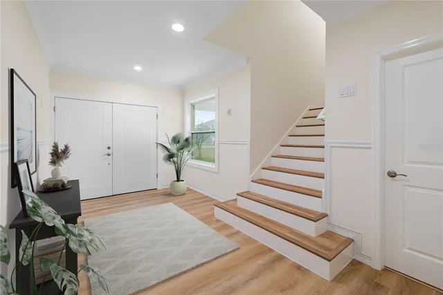 a view of a livingroom with wooden floor and stairs