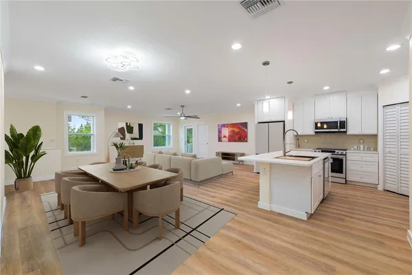 a open kitchen with white cabinets and stainless steel appliances