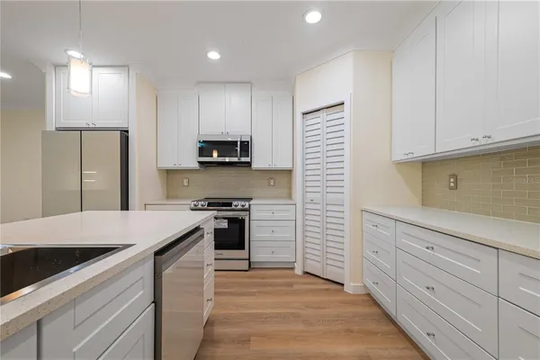 a kitchen with granite countertop cabinets stainless steel appliances and a counter space