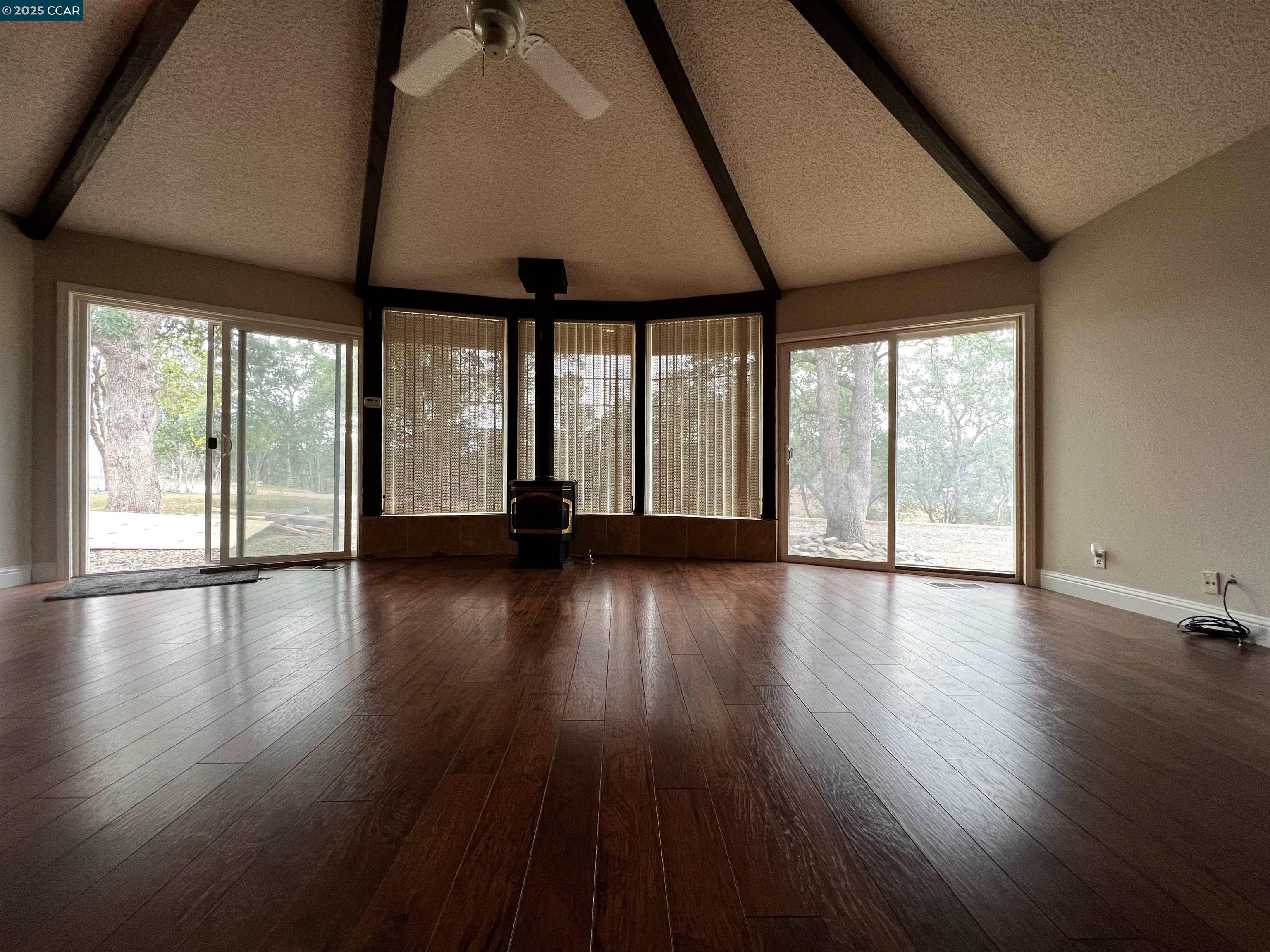 14630 St Croy Road Red Bluff, CA 96080 - Photo 14 of 29 an empty room with wooden floor and windows with curtains