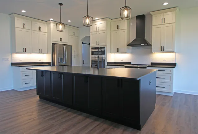 a kitchen with a sink chandelier and wooden floor