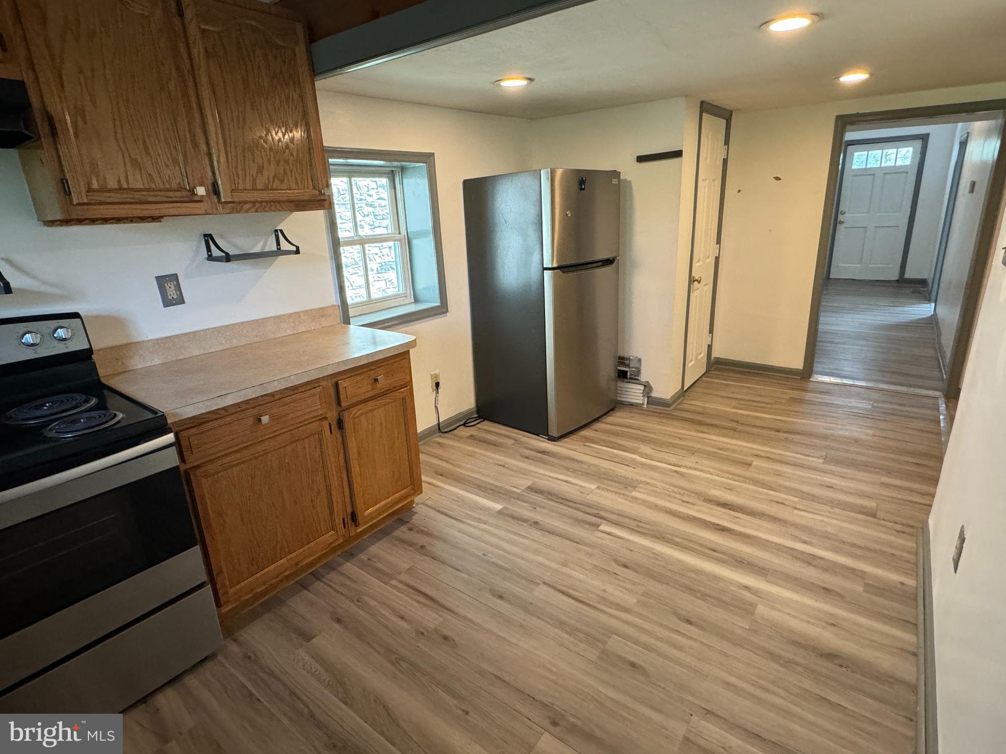 413 South Braddock Street Winchester, VA 22601 - Photo 5 of 20 a kitchen with stainless steel appliances granite countertop a refrigerator a sink dishwasher a stove and white countertops with wooden floor