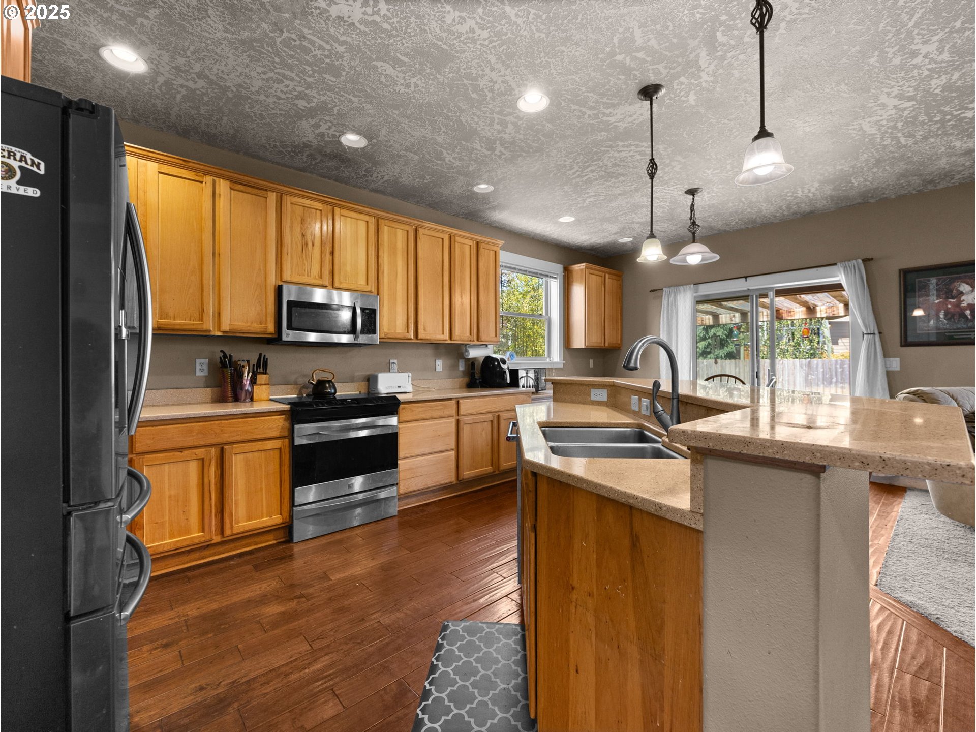 18653 Van Fleet Avenue Sandy, OR 97055 - Photo 20 of 48 a kitchen with stainless steel appliances granite countertop a sink a stove a refrigerator cabinets and a window