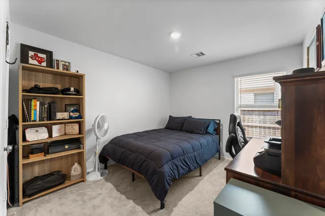 a bedroom with a bed and a book shelf