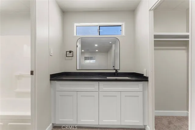 a bathroom with a granite countertop sink and a mirror