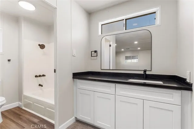 a bathroom with a granite countertop sink a mirror and a shower