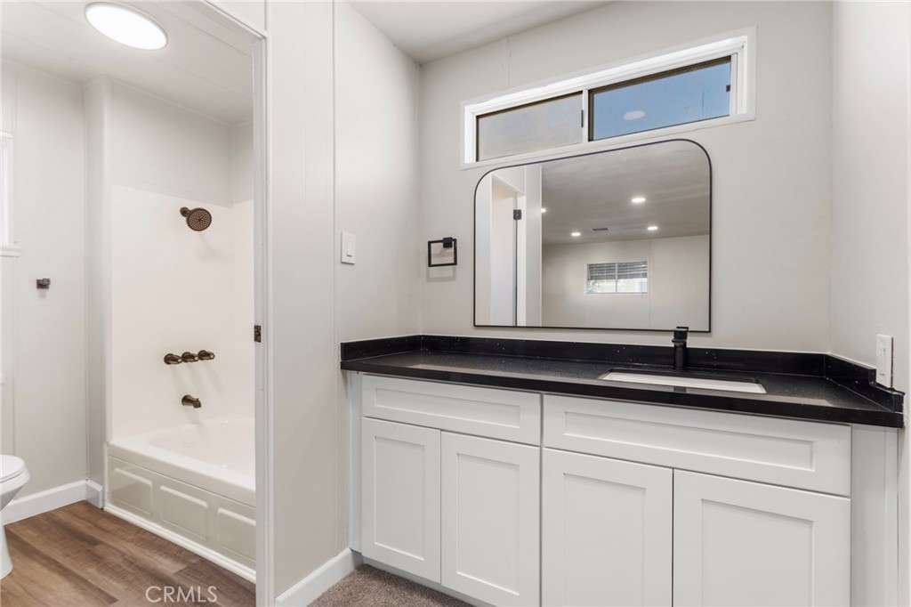 1001 West Lambert Road, Unit 179 La Habra, CA 90631 - Photo 20 of 27 a bathroom with a granite countertop sink a mirror and a shower