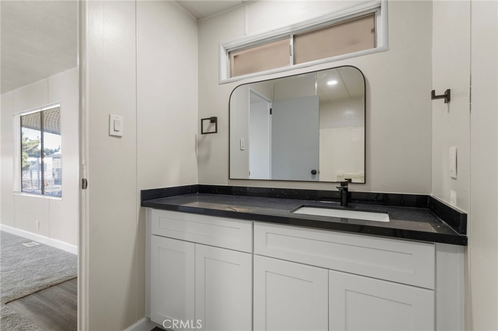1001 West Lambert Road, Unit 179 La Habra, CA 90631 - Photo 21 of 27 a bathroom with a granite countertop sink and a mirror