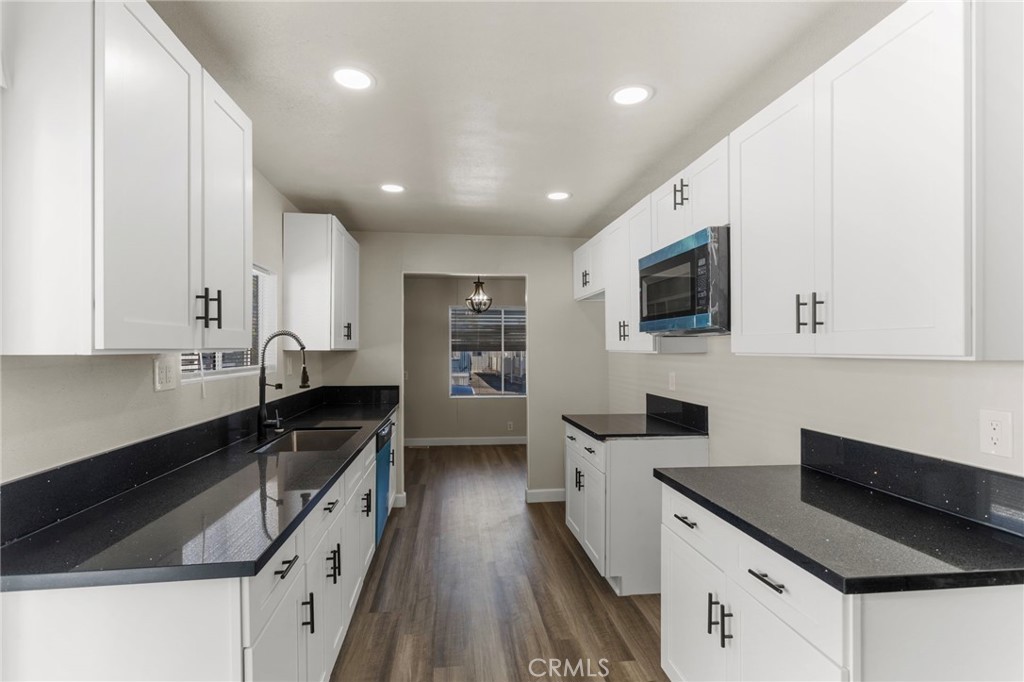 1001 West Lambert Road, Unit 179 La Habra, CA 90631 - Photo 5 of 27 a kitchen with granite countertop a sink a counter top space stainless steel appliances and cabinets