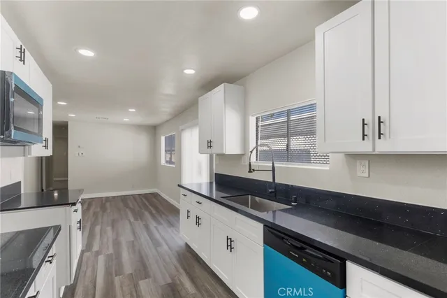 a large kitchen with stainless steel appliances a large counter top a stove and a sink