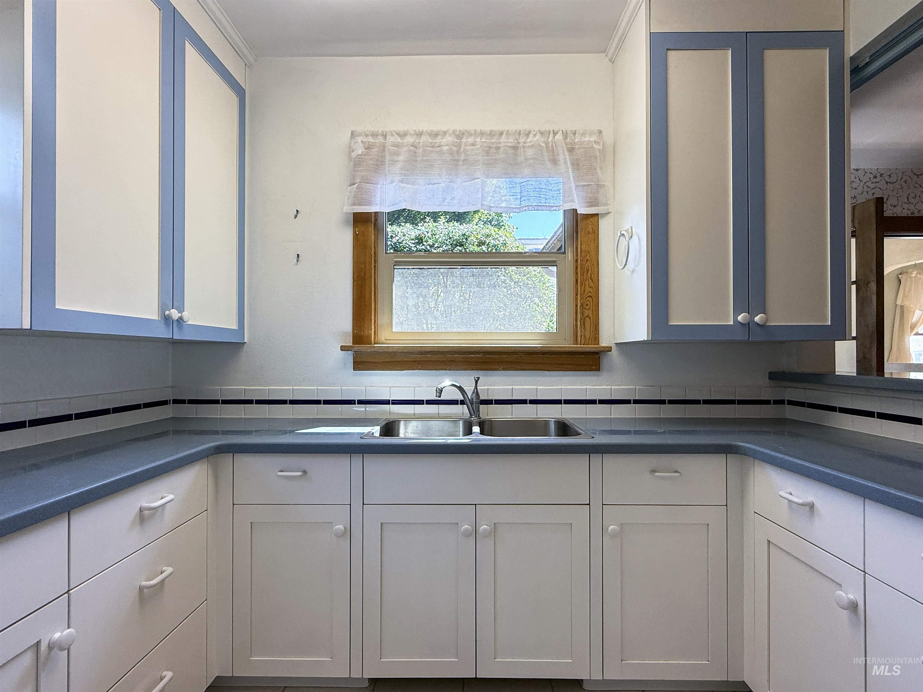504 South Hayes Street Moscow, ID 83843 - Photo 17 of 44 Kitchen with dark countertops, white cabinets, and backsplash
