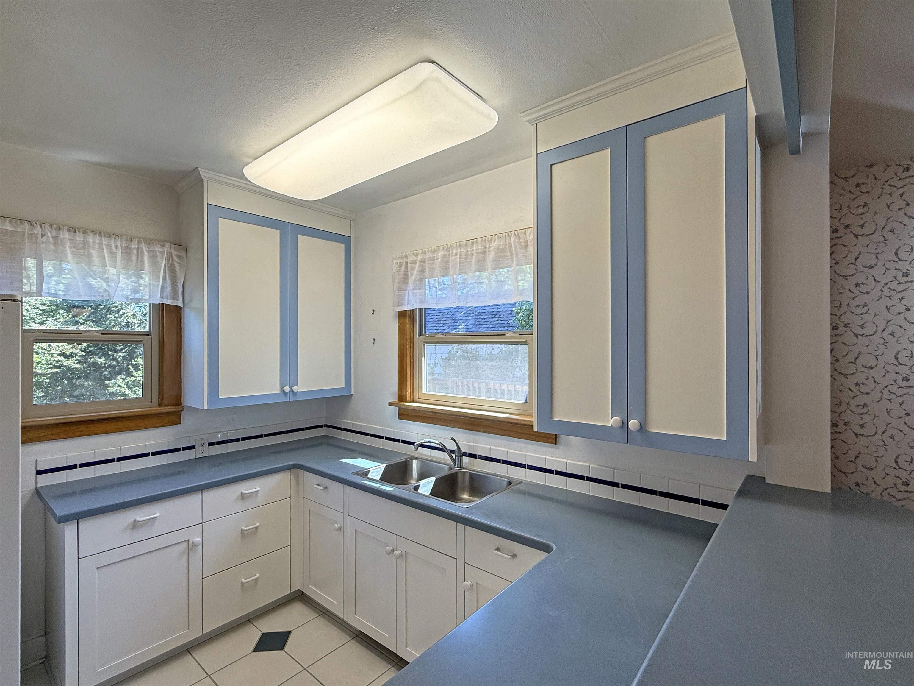 504 South Hayes Street Moscow, ID 83843 - Photo 18 of 44 Kitchen featuring dark countertops, white cabinetry, light tile patterned floors, tasteful backsplash, and ornamental molding