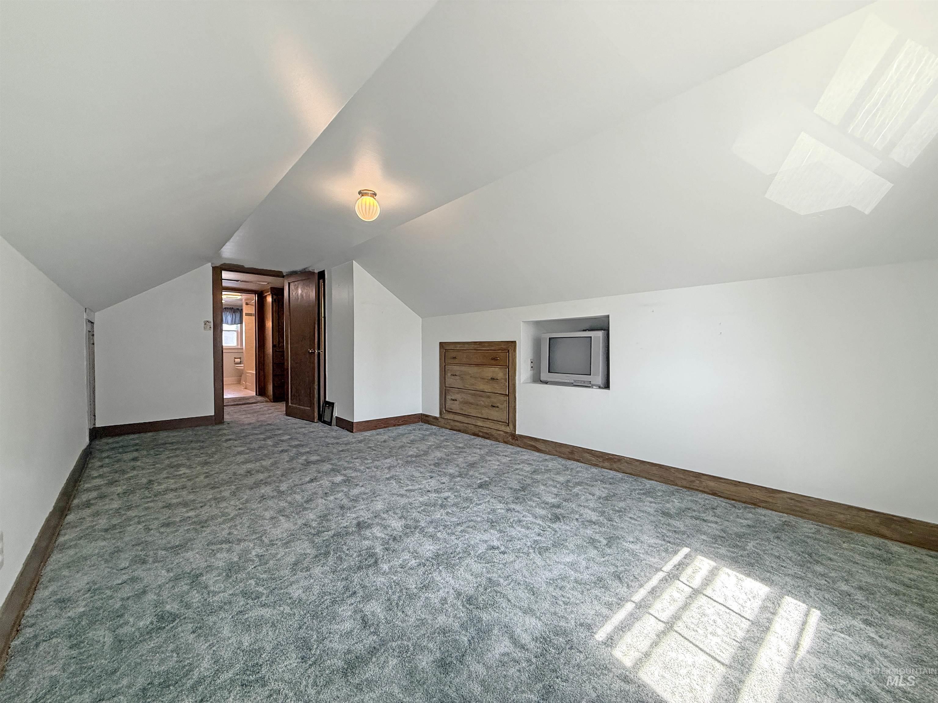 504 South Hayes Street Moscow, ID 83843 - Photo 28 of 44 Additional living space with lofted ceiling and dark carpet