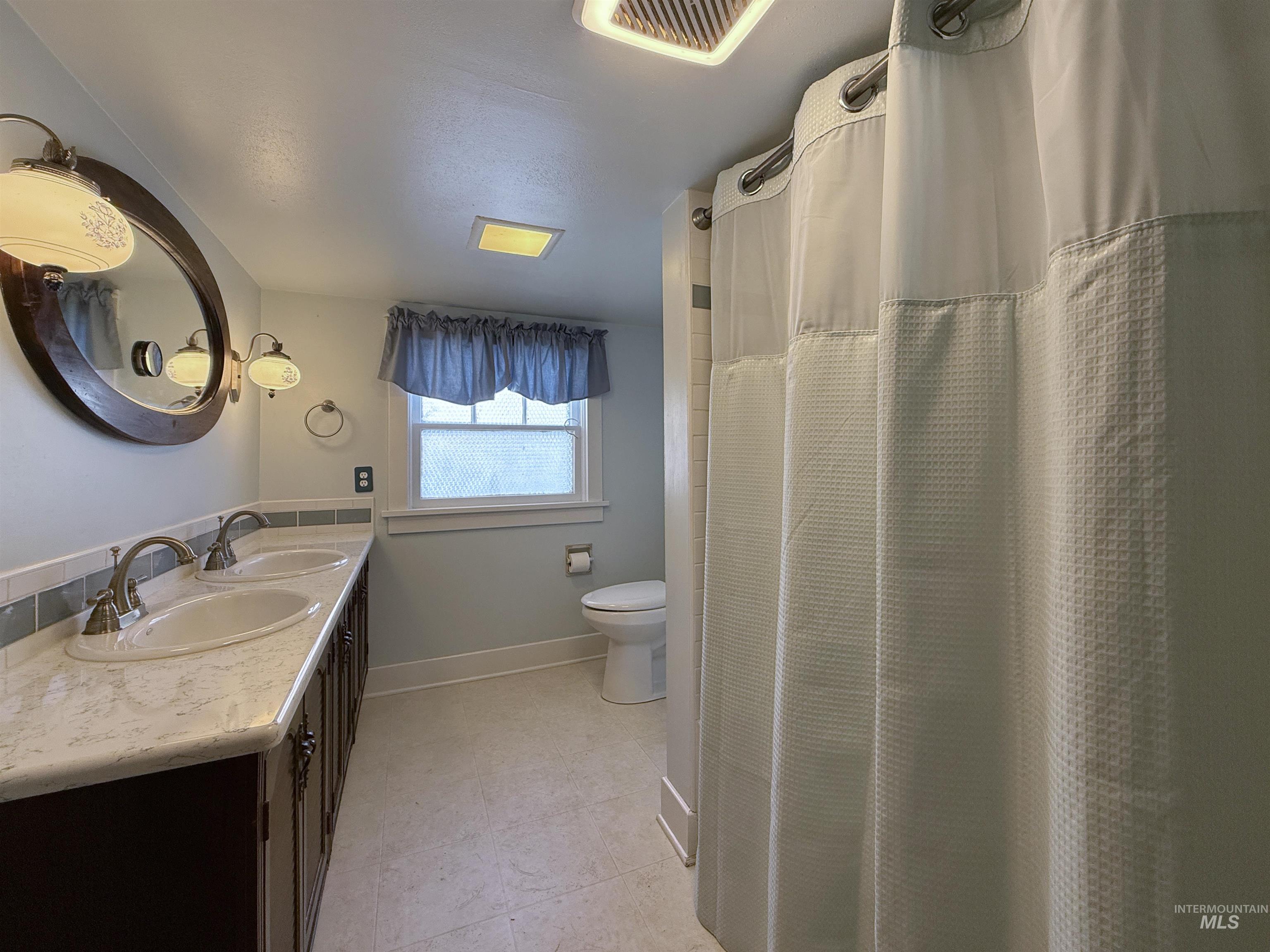 504 South Hayes Street Moscow, ID 83843 - Photo 32 of 44 Full bathroom with double vanity, light tile patterned floors, and a shower with curtain
