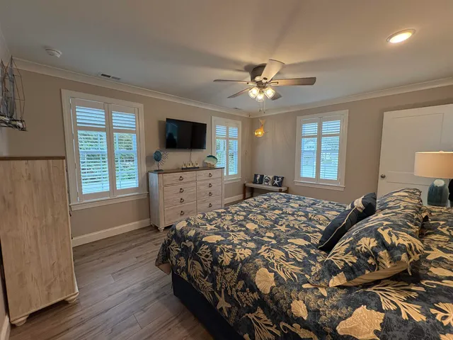 a bedroom with a bed window and a flat screen tv