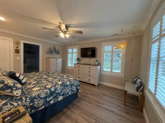 a bedroom with a bed a window and a flat screen television