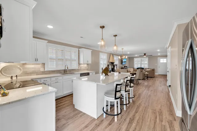 a kitchen with a sink and a stove with white cabinets