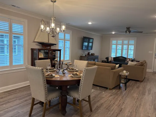 a view of a dining room with furniture a chandelier and wooden floor