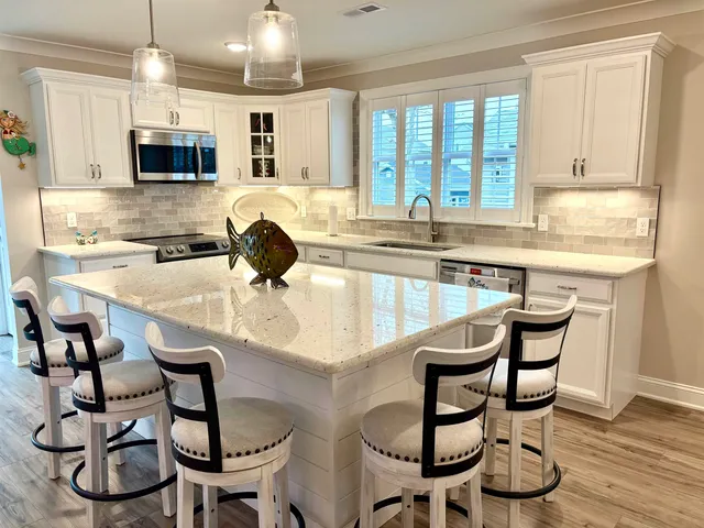 a kitchen with granite countertop a table chairs microwave and cabinets
