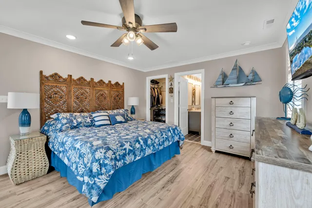 a bedroom with a large bed a chandelier and a dresser