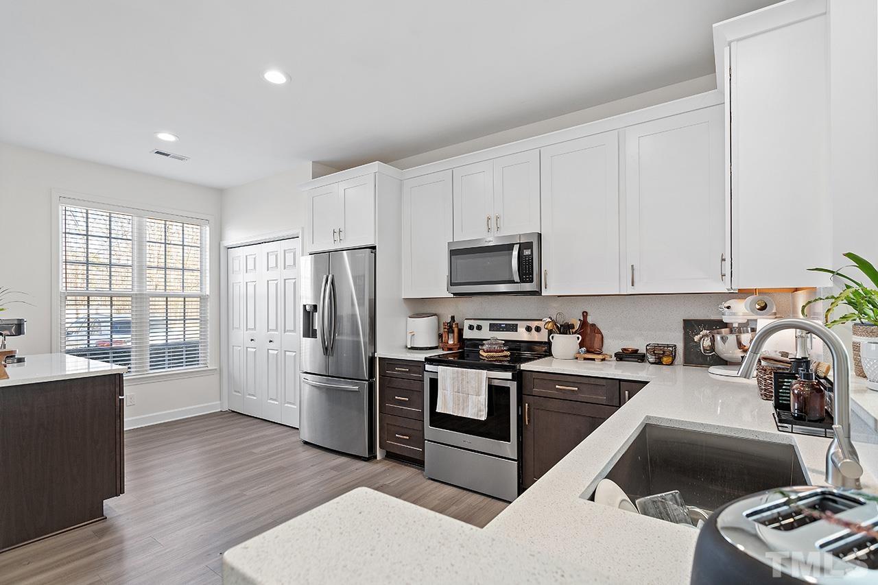 844 Horton Road, Unit 32 Durham, NC 27704 - Photo 5 of 17 a kitchen with stainless steel appliances a sink a stove a refrigerator cabinets and a window
