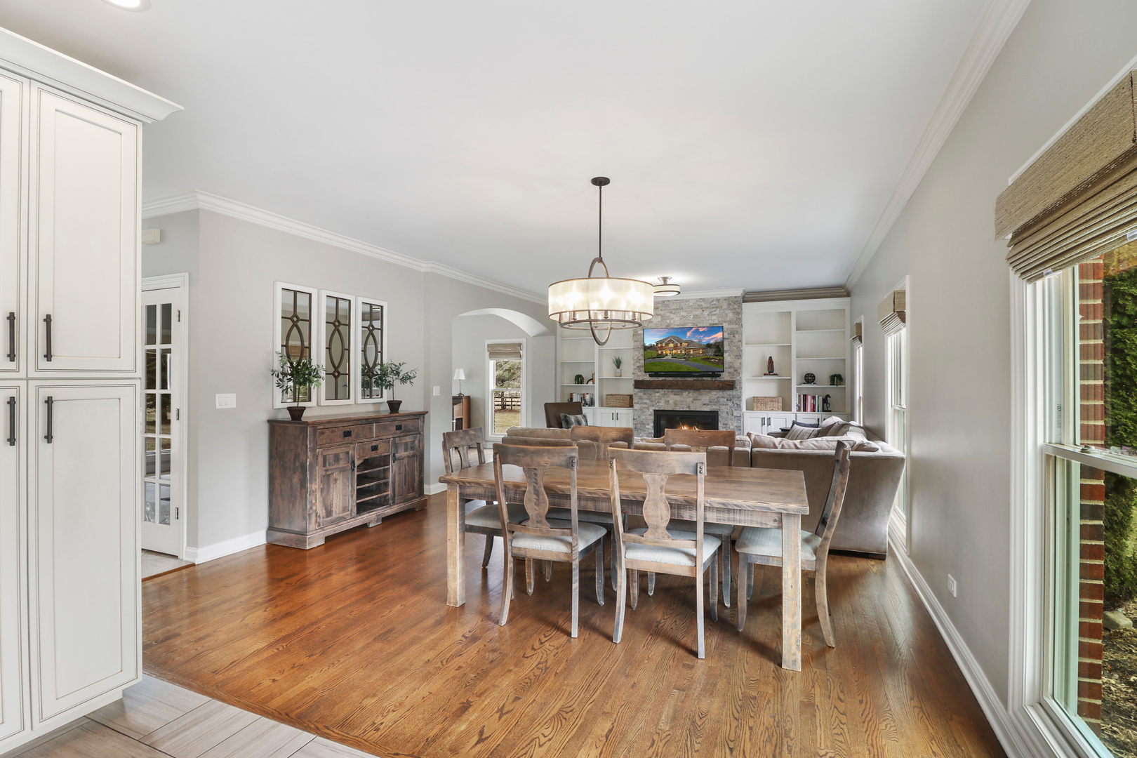 206 Spring Creek Road Barrington Hills, IL 60010 - Photo 13 of 56 a view of a dining room and livingroom with furniture wooden floor a rug a chandelier and a mirror