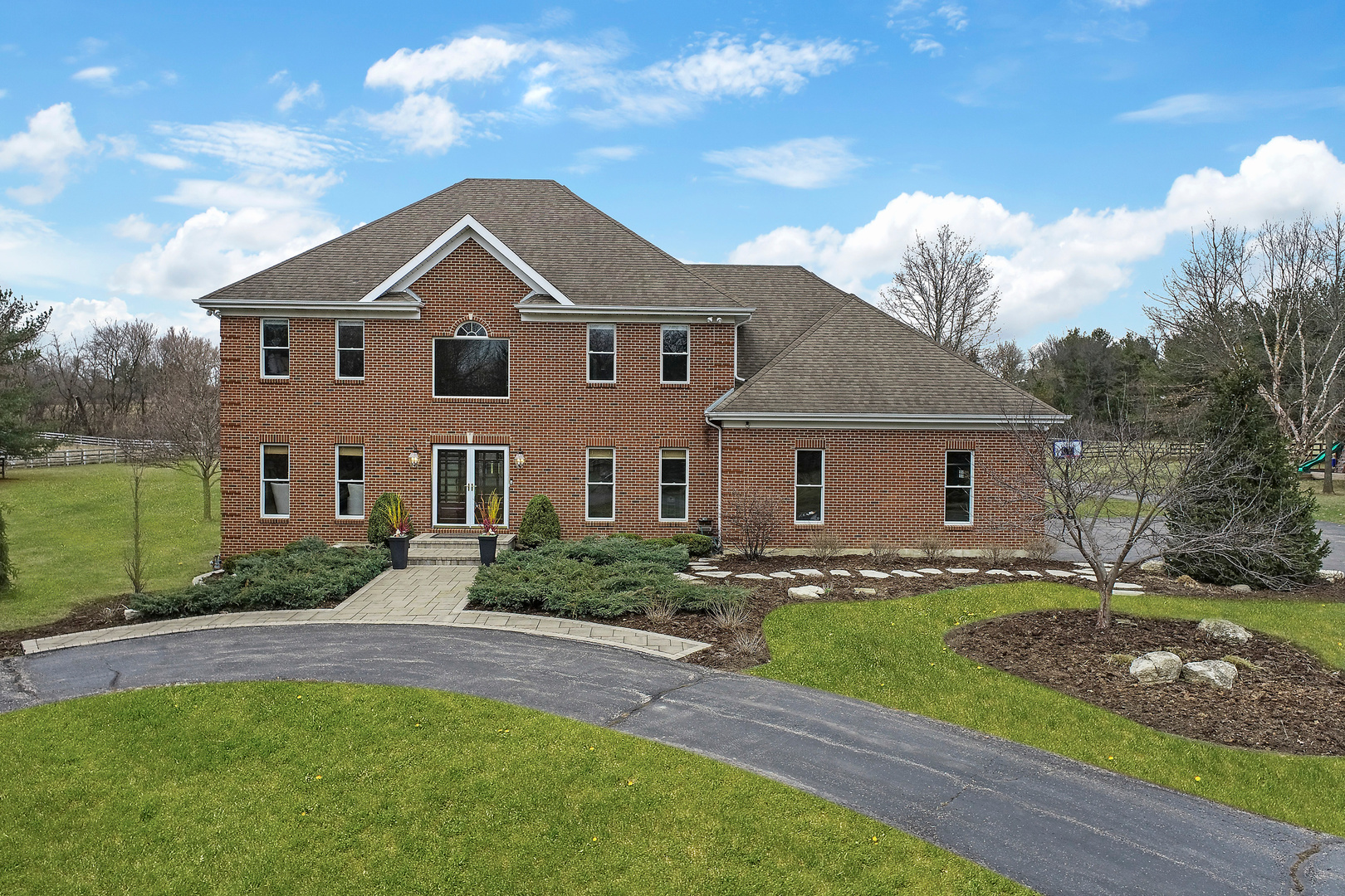 206 Spring Creek Road Barrington Hills, IL 60010 - Photo 39 of 56 a front view of a house with a yard and garage